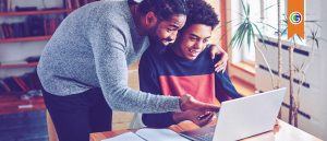 Advisor supporting high school student with college prep at a laptop.