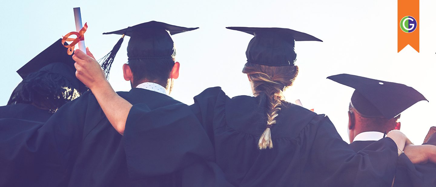 In this image, a group of graduates wearing black caps and gowns stand arm-in-arm, facing away from the camera toward a bright sky. In the top right corner, an orange bookmark shape contains the circular green and purple GEAR UP logo. One graduate in the image holds up a diploma with an orange ribbon as they celebrate their graduation together.